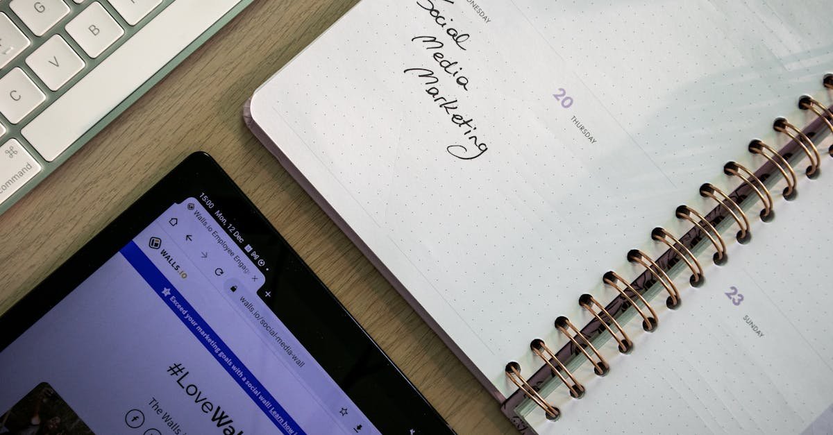 Top view of a notebook, tablet, and keyboard used for social media marketing planning.